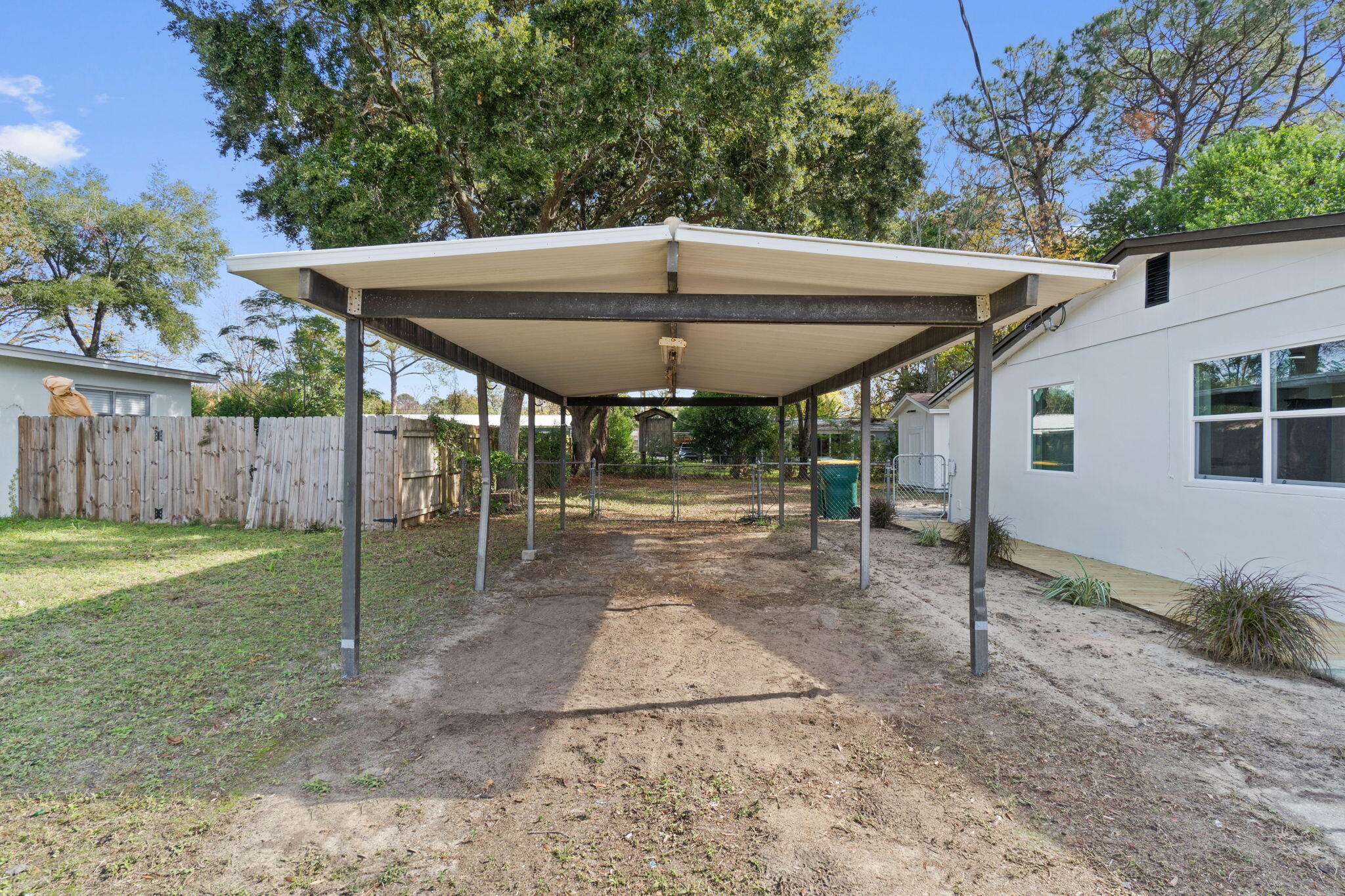 630 Shrewsbury Road Mary Esther, FL 32569 - Photo 39 of 39 a view of a backyard with table and chairs under an umbrella with wooden fence
