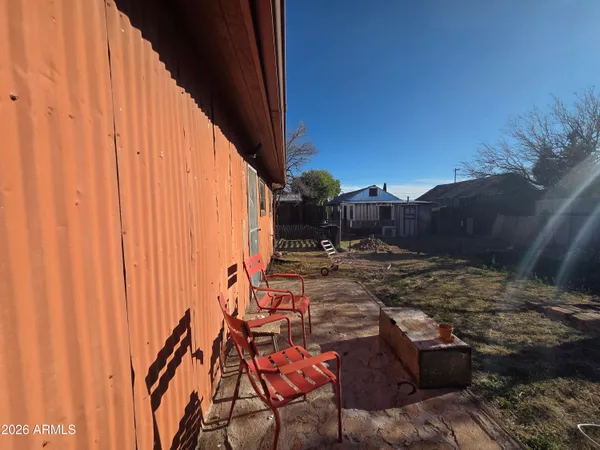 a view of backyard with swimming pool and seating space