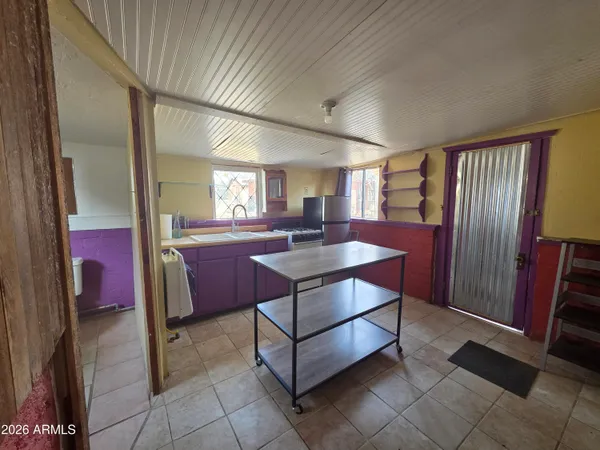 a living room with a table chairs and wooden cabinets