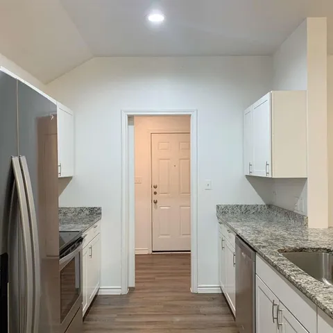 a kitchen with stainless steel appliances granite countertop a refrigerator and a sink