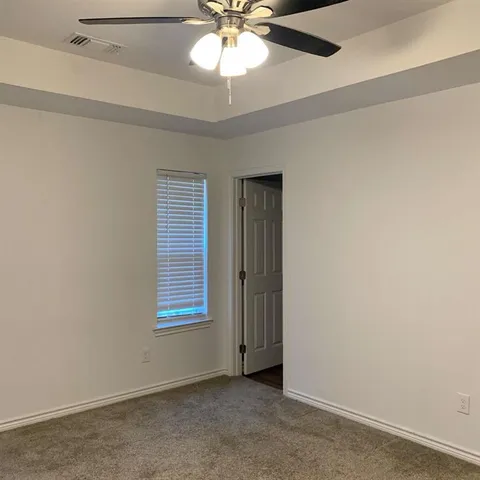 an empty room with windows and fan