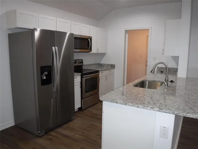 a kitchen with stainless steel appliances granite countertop a refrigerator and a sink