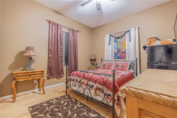 a bedroom with a bed and a flat tv screen on dresser