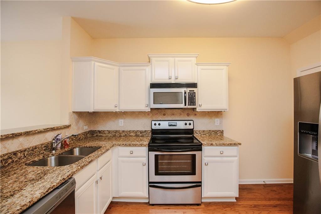 3801 Thayer Trace Duluth, GA 30096 - Photo 15 of 44 a kitchen with stainless steel appliances a stove and white cabinets