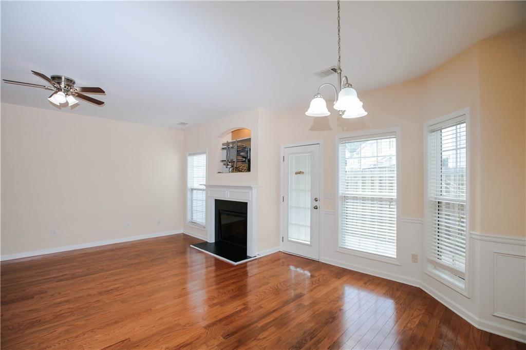 3801 Thayer Trace Duluth, GA 30096 - Photo 10 of 44 an empty room with wooden floor fireplace and windows