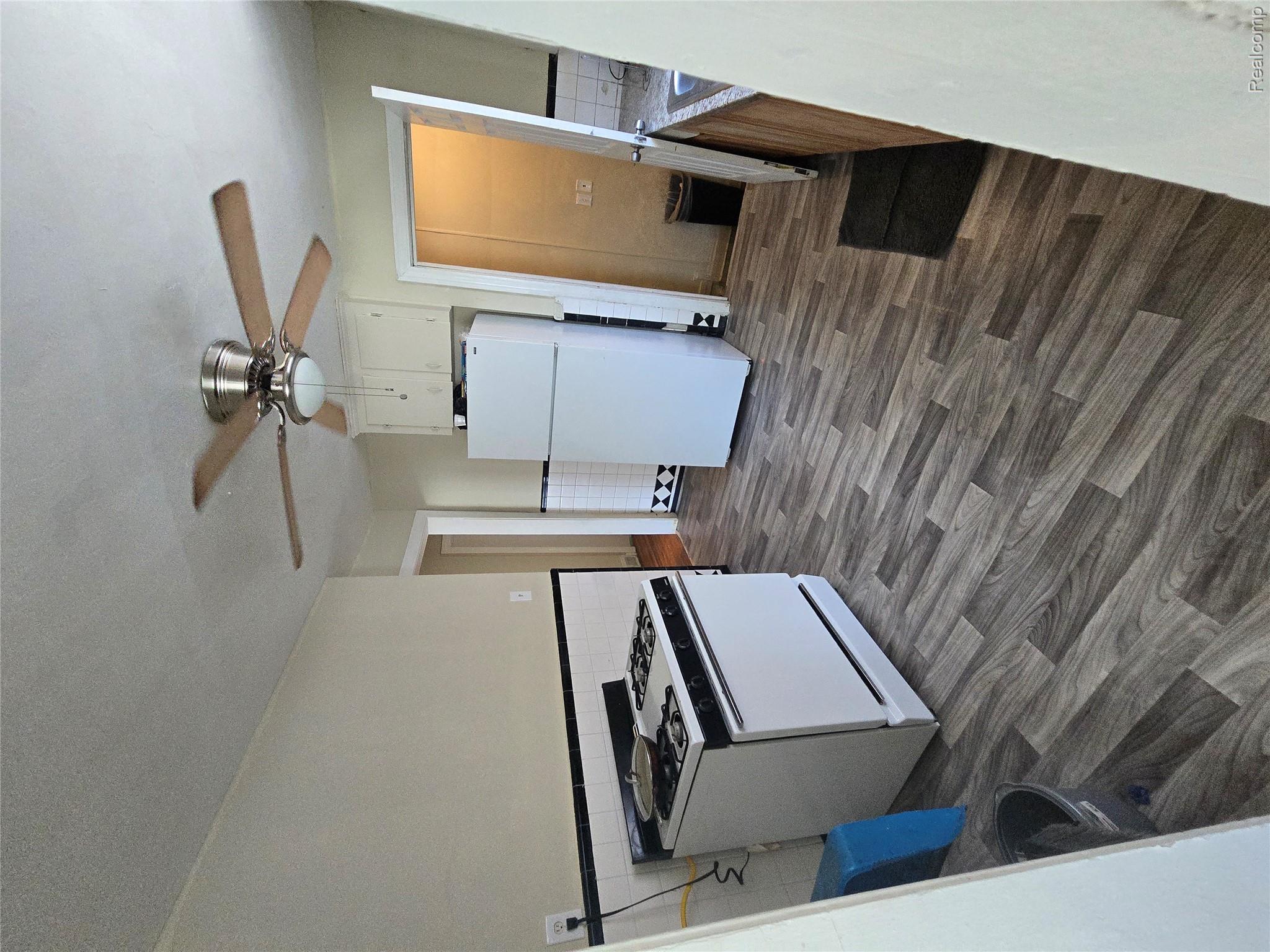 10342 Roxbury Street Detroit, MI 48224 - Photo 14 of 30 Kitchen with wood-finish flooring, white appliances, and a ceiling fan with integrated lighting