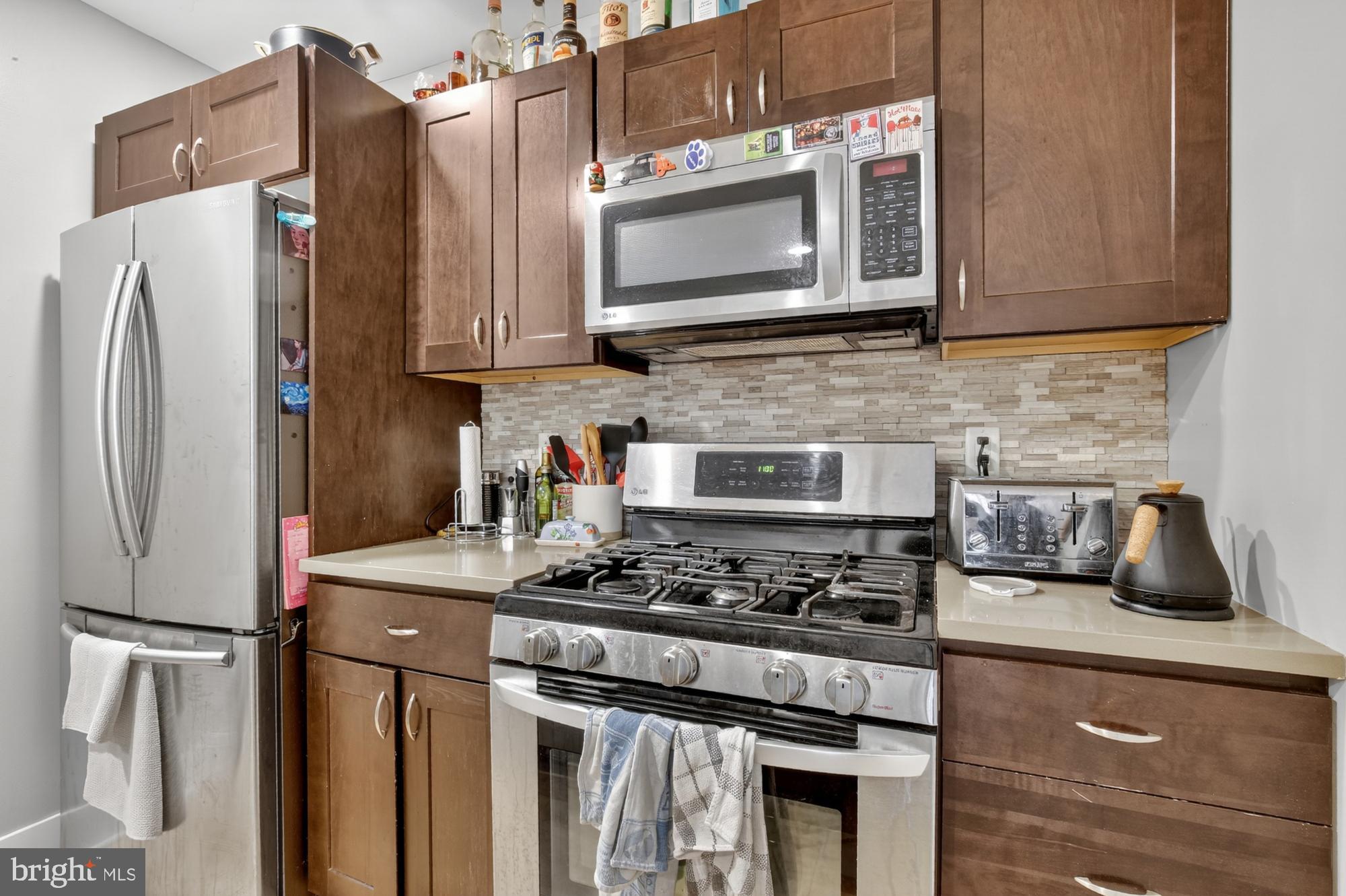 709 North 3rd Street, Unit 3 Philadelphia, PA 19123 - Photo 8 of 17 a kitchen with stainless steel appliances granite countertop a stove a refrigerator and a microwave