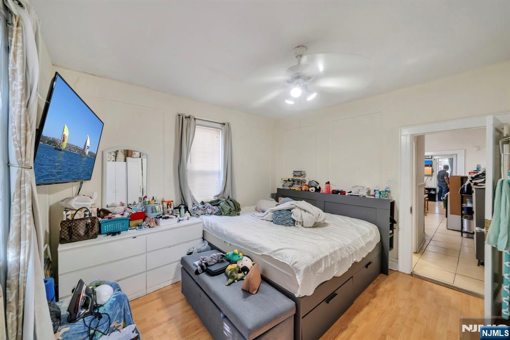 688 Passaic Avenue Nutley, NJ 07110 - Photo 40 of 42 a bed room with a bed mirror and a flat screen tv