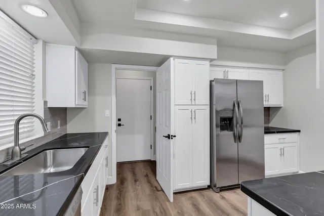 a kitchen with stainless steel appliances granite countertop a refrigerator and a sink