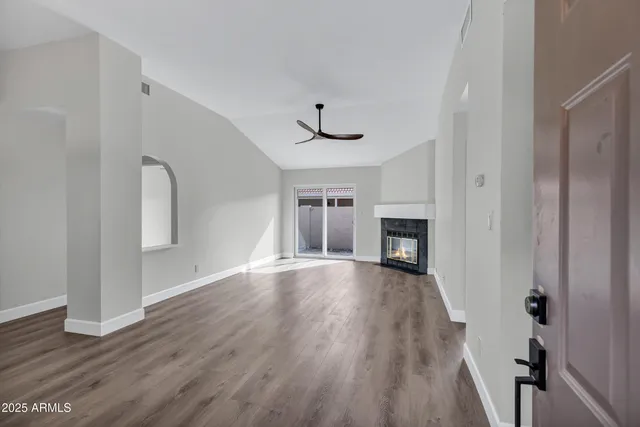 a view of empty room with wooden floor and fireplace