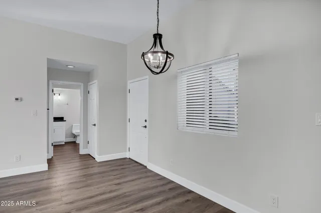 a view of empty room with wooden floor and window