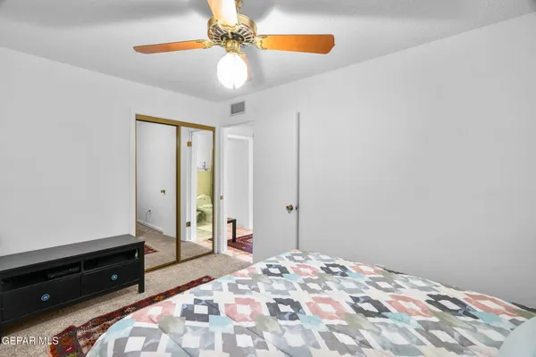 a bedroom with a bed and ceiling fan