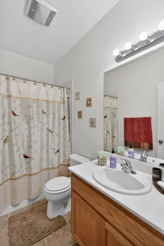 a bathroom with a granite countertop sink a toilet and shower