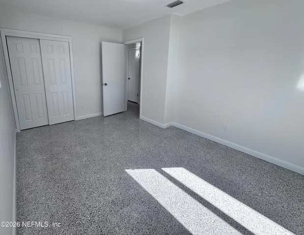 a view of an empty room and a ceiling fan window