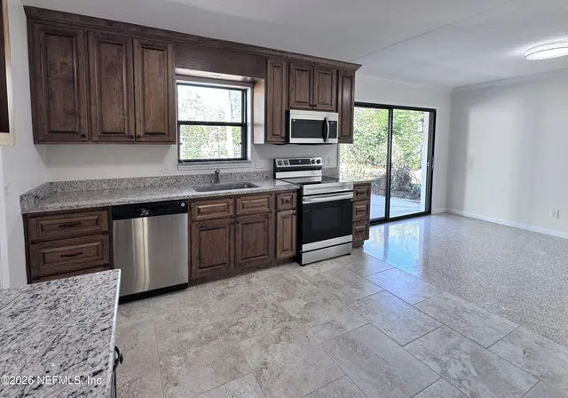 a kitchen with stainless steel appliances granite countertop a refrigerator a sink a stove and island