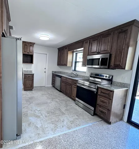 a view of a kitchen with a sink oven large window and a kitchen