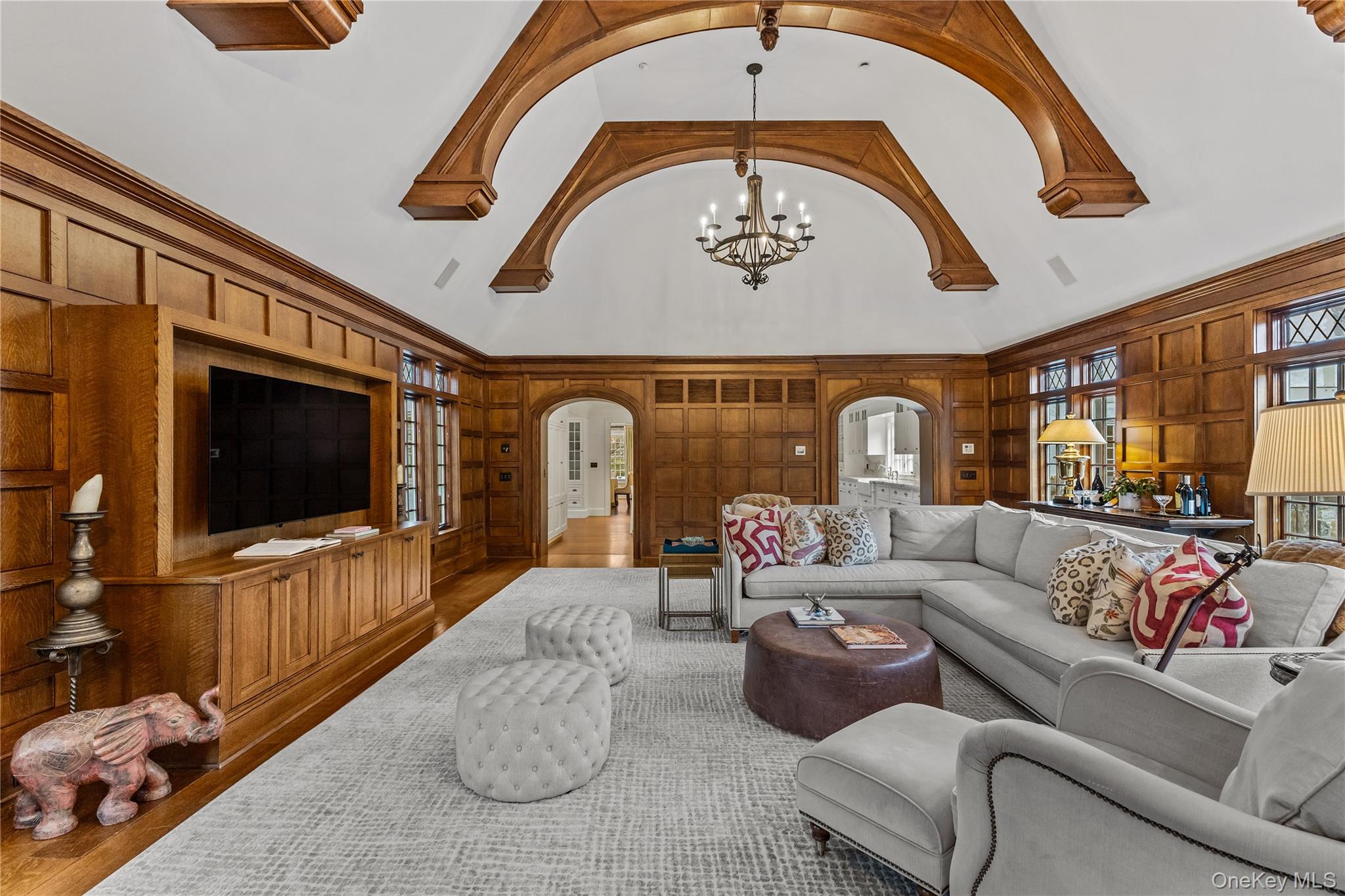 19 Park Drive South Rye, NY 10580 - Photo 20 of 42 Living area with a high ceiling, arched walkways, built in features, wooden walls, and wood finished floors