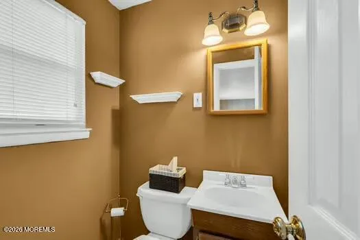 a bathroom with a toilet a sink and mirror