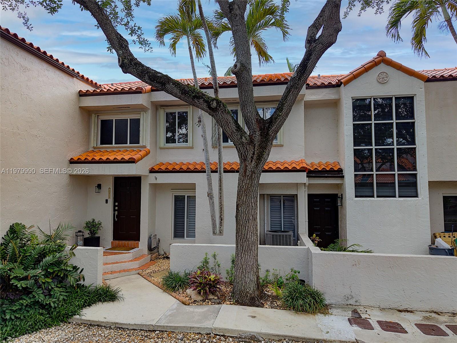 10978 Southwest 75th Terrace Miami, FL 33173 - Photo 21 of 34 a front view of a house with glass windows and plants