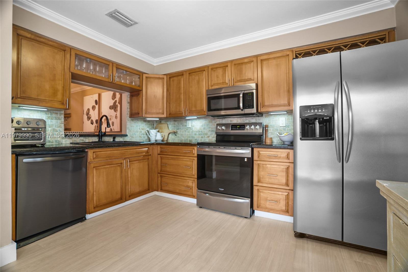 10978 Southwest 75th Terrace Miami, FL 33173 - Photo 5 of 34 a kitchen with granite countertop a refrigerator stove top oven and sink