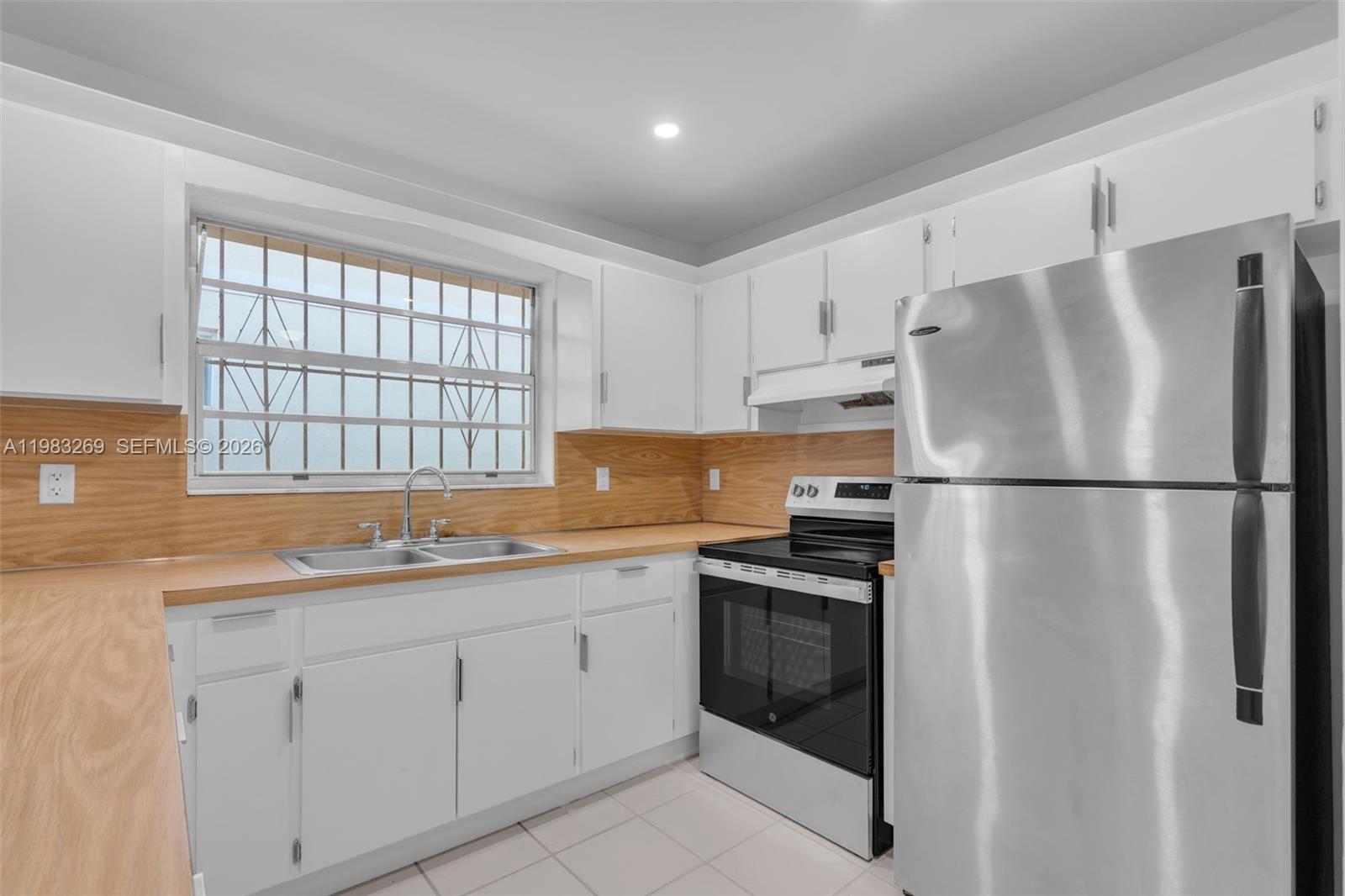 3572 Southwest 25th Street Miami, FL 33133 - Photo 10 of 18 a kitchen with a refrigerator sink and cabinets