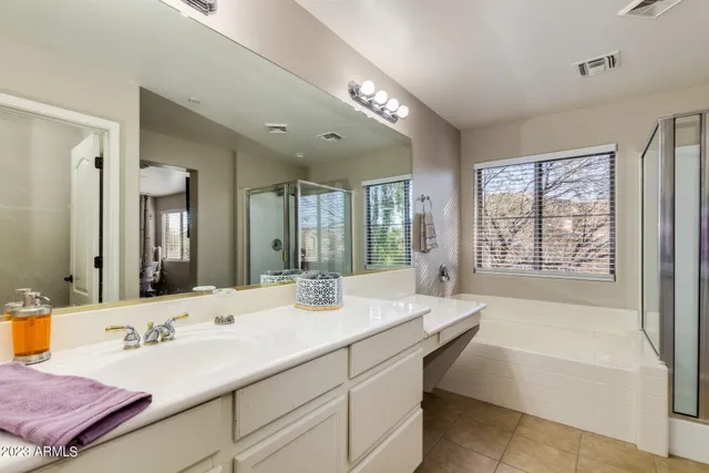 a bathroom with a tub double vanity sink and mirror