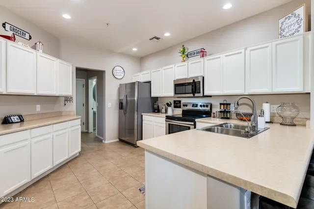a kitchen with stainless steel appliances a refrigerator sink and microwave