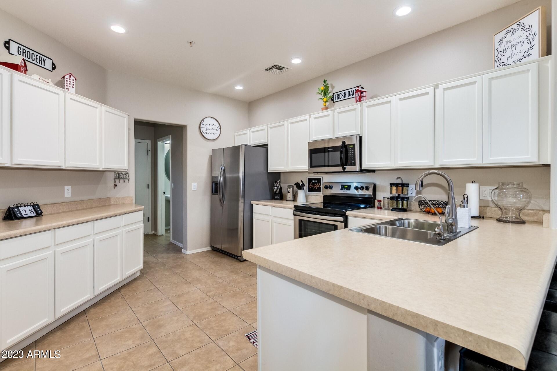 5415 East McKellips Road, Unit 94 Mesa, AZ 85215 - Photo 18 of 64 a kitchen with stainless steel appliances a refrigerator sink and microwave