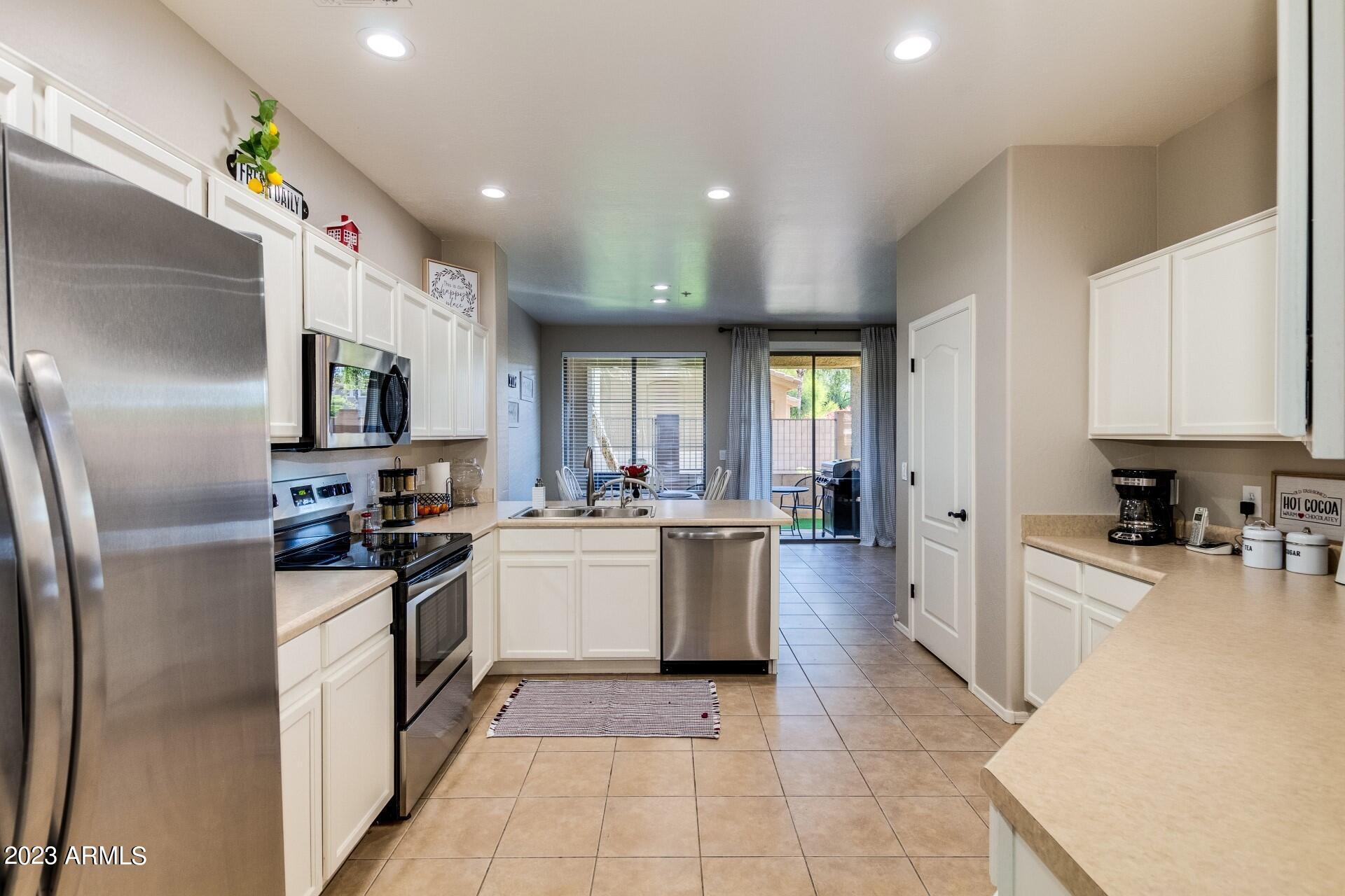 5415 East McKellips Road, Unit 94 Mesa, AZ 85215 - Photo 19 of 64 a kitchen with stainless steel appliances granite countertop a refrigerator and a stove top oven