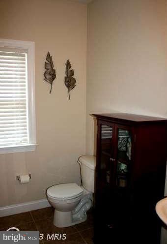 4027 Brummel Road Pasadena, MD 21122 - Photo 13 of 25 a bathroom with a toilet and a painting on the wall