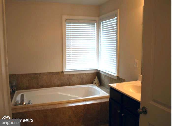 4027 Brummel Road Pasadena, MD 21122 - Photo 18 of 25 a bath tub sitting in a bathroom next to a window