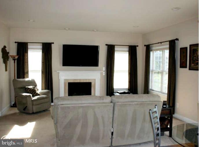 4027 Brummel Road Pasadena, MD 21122 - Photo 3 of 25 a living room with furniture a flat screen tv and a fireplace