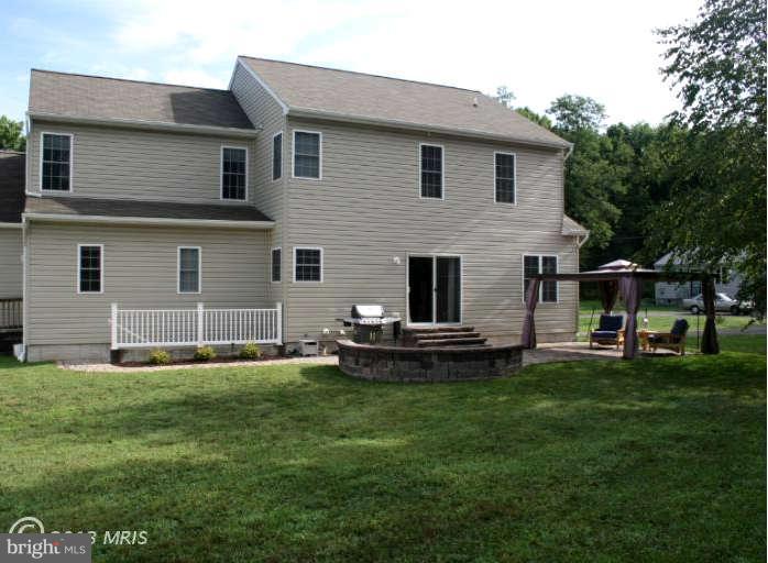 4027 Brummel Road Pasadena, MD 21122 - Photo 24 of 25 a front view of a house with a garden and yard