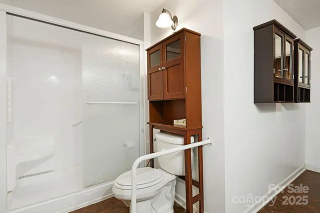 a bathroom with a toilet and a shower