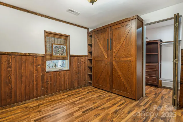 a view of empty room with wooden floor and closet