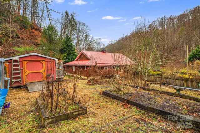 a backyard of a house with table and chairs under an umbrella