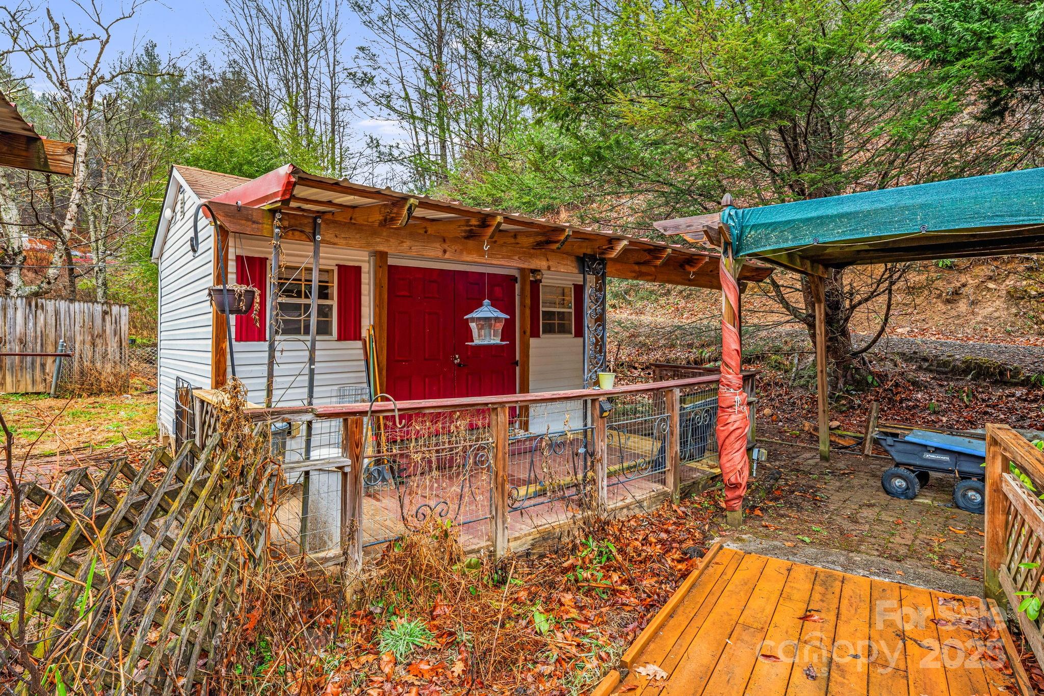 814 Little Creek Road Burnsville, NC 28714 - Photo 27 of 32 a view of a patio with table and chairs with wooden floor and fence