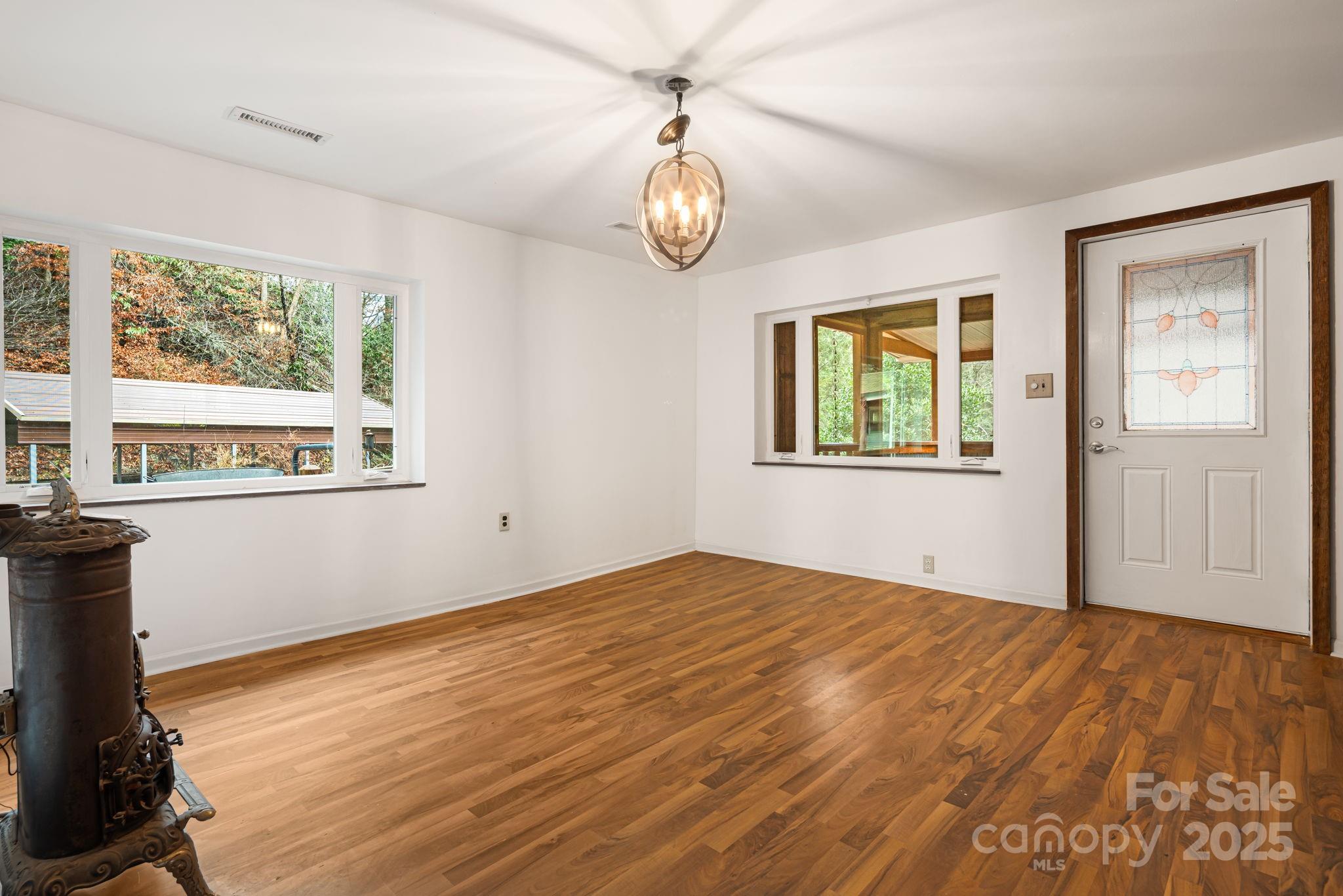 814 Little Creek Road Burnsville, NC 28714 - Photo 5 of 32 a view of an empty room with window and wooden floor