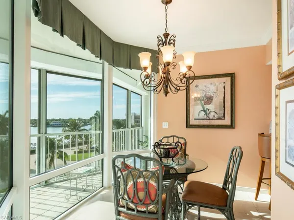 a dining room with furniture a chandelier and wooden floor
