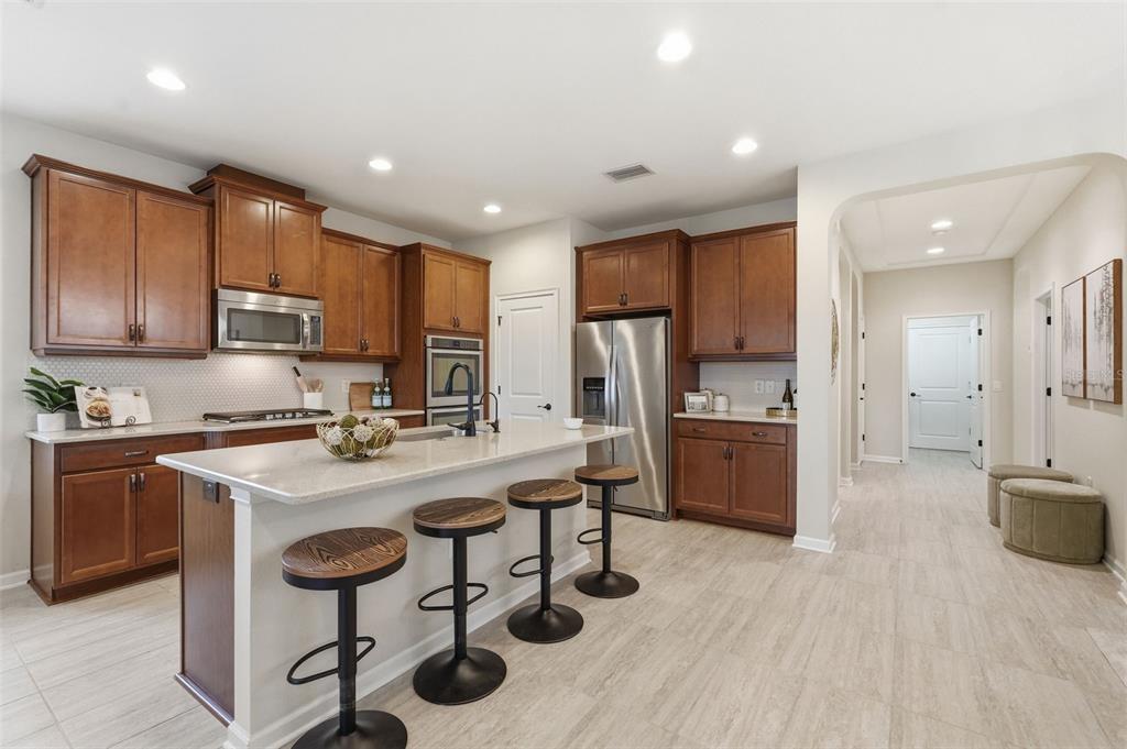 29241 Perilli Place Wesley Chapel, FL 33543 - Photo 11 of 53 a kitchen with refrigerator and chairs