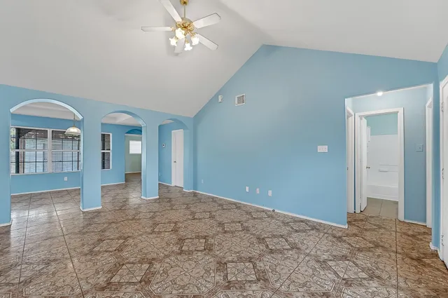 a view of a big room with chandelier fan and windows