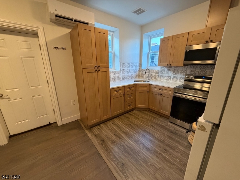 64 Mott Street, Unit 2 Newark, NJ 07105 - Photo 11 of 14 a kitchen with wooden cabinets and stainless steel appliances