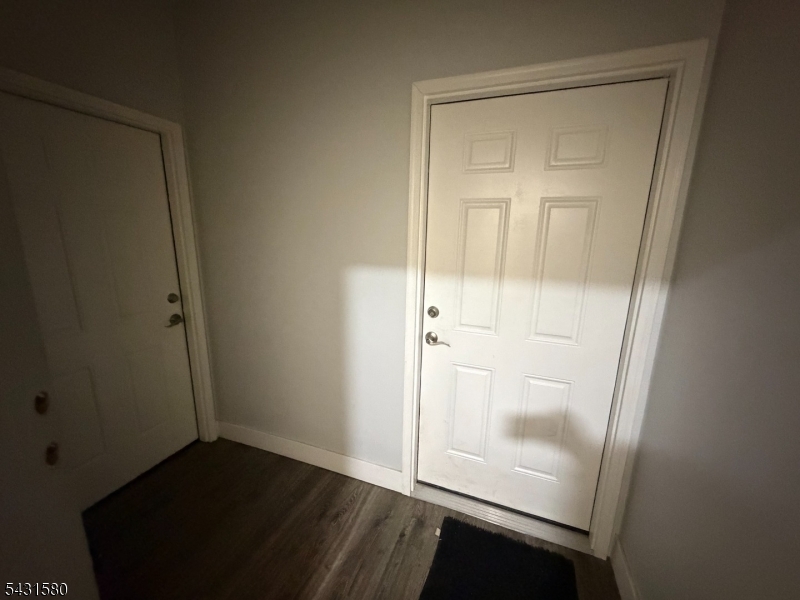 64 Mott Street, Unit 2 Newark, NJ 07105 - Photo 12 of 14 an empty room with wooden floor and mirror