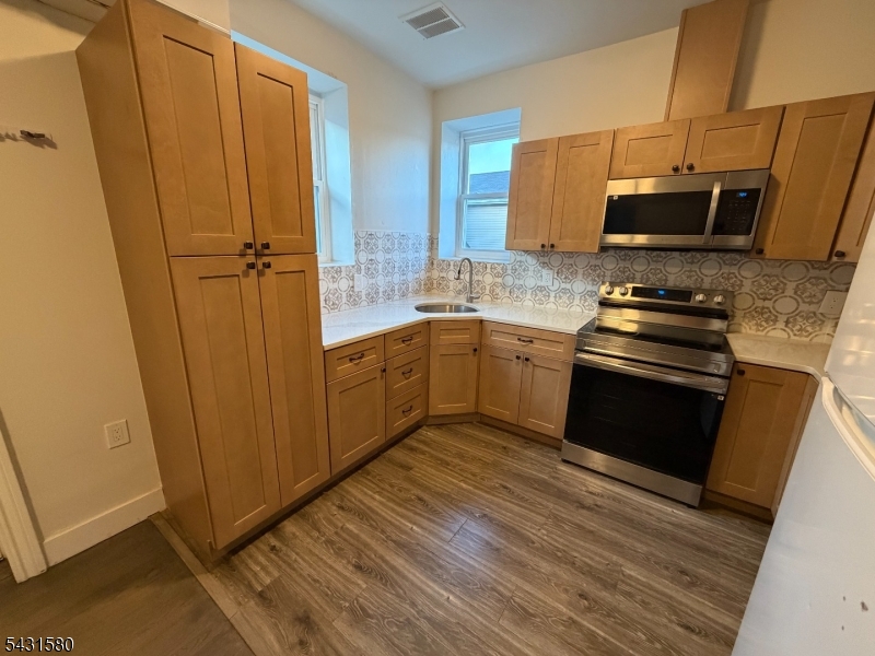 64 Mott Street, Unit 2 Newark, NJ 07105 - Photo 2 of 14 a kitchen with stainless steel appliances granite countertop a stove a sink and a refrigerator