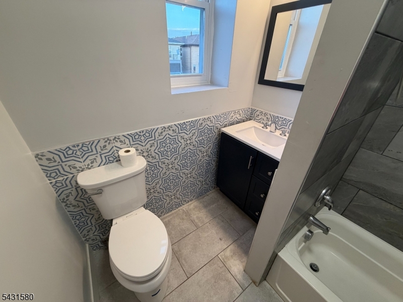 64 Mott Street, Unit 2 Newark, NJ 07105 - Photo 6 of 14 a bathroom with a toilet sink and mirror
