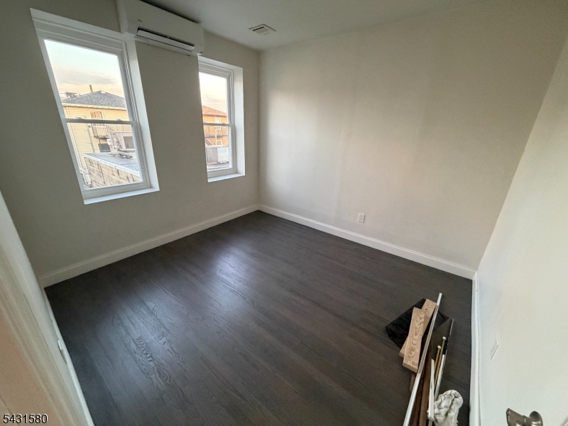 64 Mott Street, Unit 2 Newark, NJ 07105 - Photo 8 of 14 an empty room with wooden floor and windows