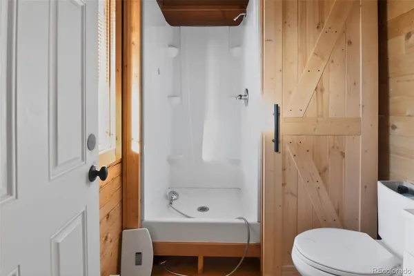 a bathroom with a shower a toilet and a sink