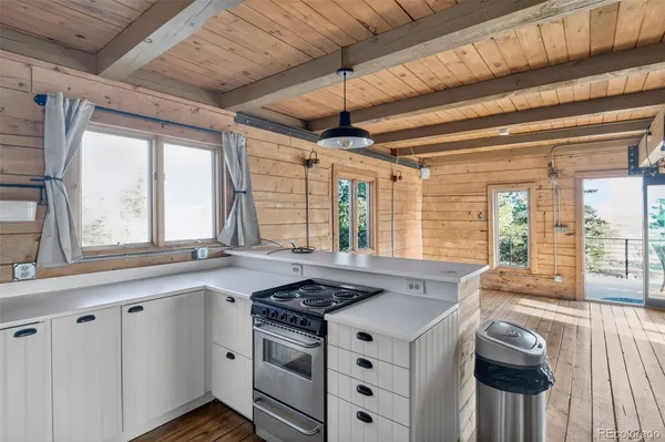 a kitchen with stainless steel appliances a stove a sink and a large window