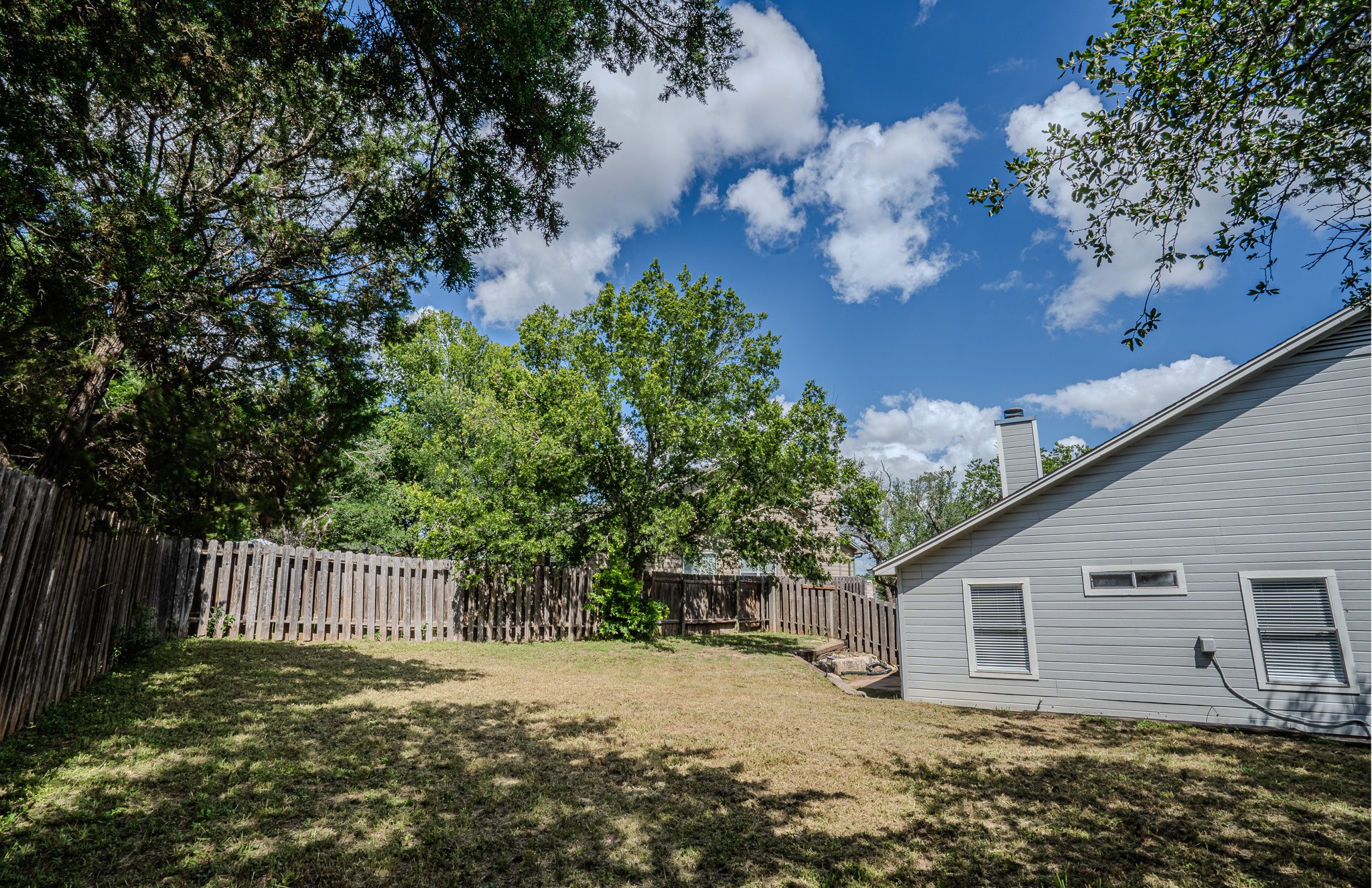 517 Cutty Trail, Unit B Lakeway, TX 78734 - Photo 16 of 16 A spacious, fenced backyard offers a private natural retreat with ample shade trees.