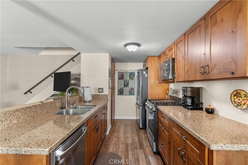28152 Robin Avenue Saugus, CA 91350 - Photo 15 of 49 a kitchen with stainless steel appliances granite countertop a sink a stove and a refrigerator